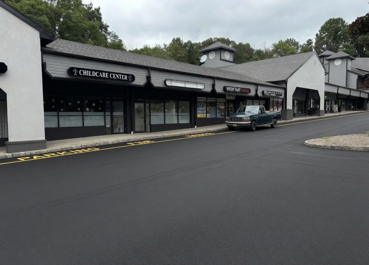 Crossroads Center after renovation — modern dark stucco and Hardie plank facade with black accents and freshly sealcoated parking lot