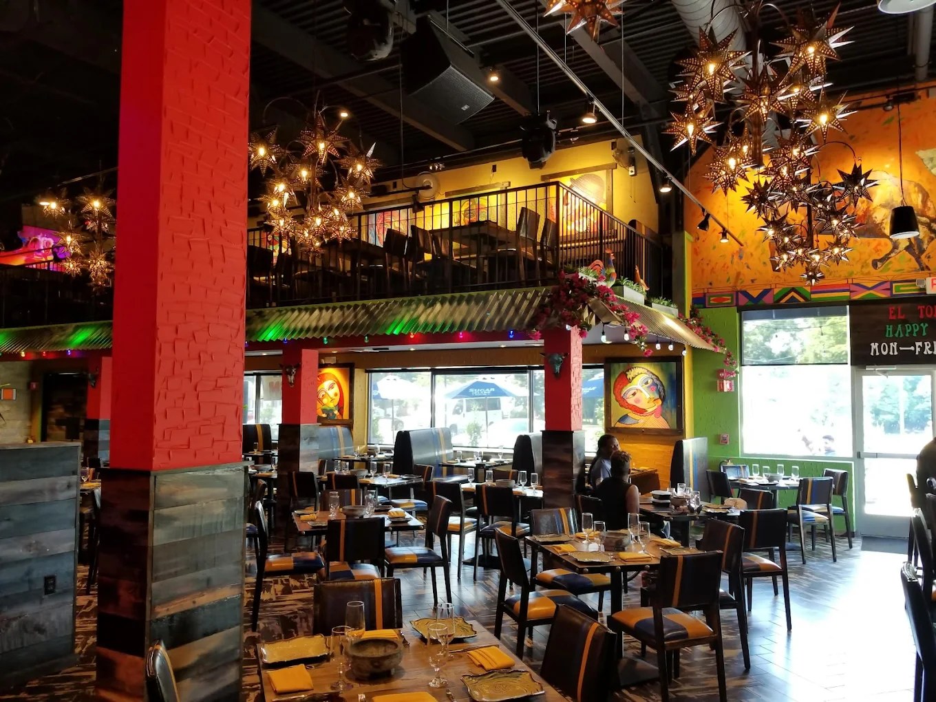 Interior of El Toro Loco — vibrant dining room with custom star light fixtures, murals, and club-grade lighting built out by Brunswick Properties