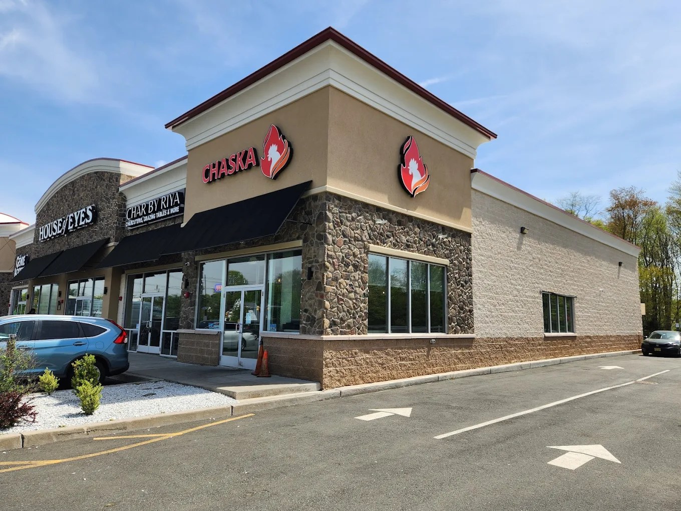 Riya Commons completed — modern stone-and-stucco storefronts leased to Chaska, Char by Riya, House of Eyes, and Genie Academy